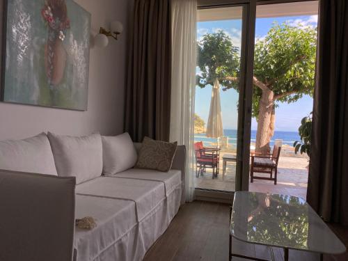 a living room with a couch and a view of the ocean at Nostos in Patitiri