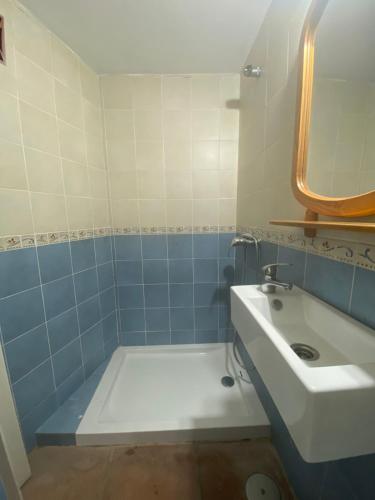 a blue and white bathroom with a sink and a tub at Cuarto encantador rústico in Los Barrios