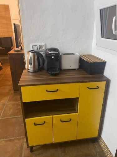 a yellow dresser with utensils on top of it at Cuarto encantador rústico in Los Barrios