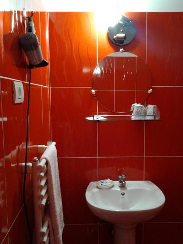 a red bathroom with a sink and a mirror at Vilele Brise de Mer in 2 Mai