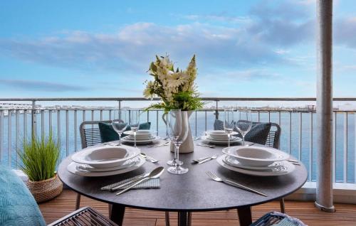 a table on a balcony with a view of the ocean at Ms Admiral in Olpenitz