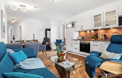 a living room with blue chairs and a kitchen at Ms Admiral in Olpenitz