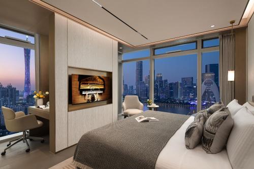 a bedroom with a bed with a view of a city at Ascott Pazhou Guangzhou in Guangzhou