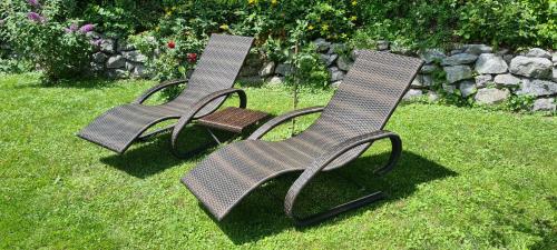 two chairs sitting in the grass in a yard at Ferienwohnung Blumäcker Oberbayern in Oberhausen