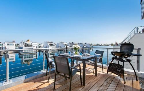 een tafel en stoelen op een balkon met uitzicht op het water bij Beluga in Olpenitz