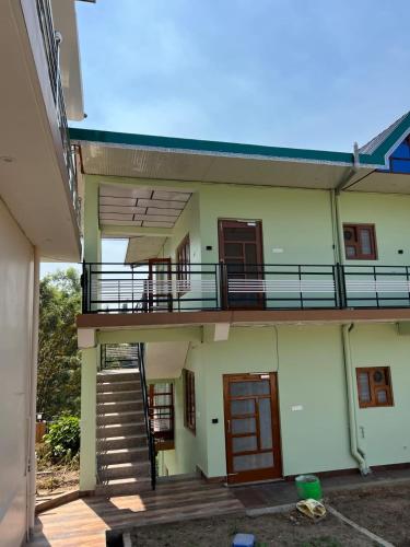 an external view of a building with a balcony at Riverside Villa Dharamsala in Dharmsala