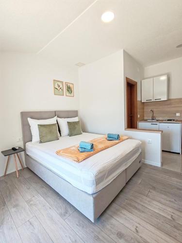a large bed in a room with a kitchen at Apartments Kata in Neum