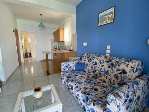 a living room with a couch and a blue wall at Nostos in Patitiri