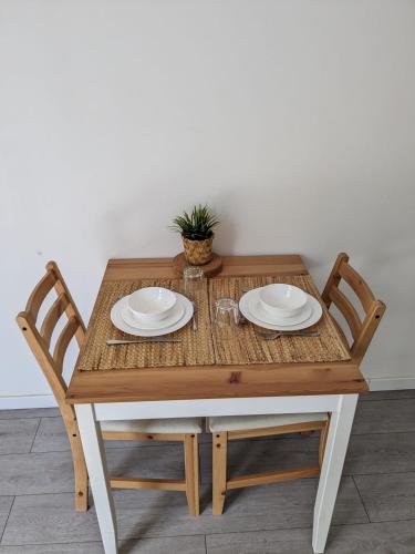 une table en bois avec deux plaques et une plante sur celle-ci, dans l'établissement Studio Faubourg-Raines, à Dijon