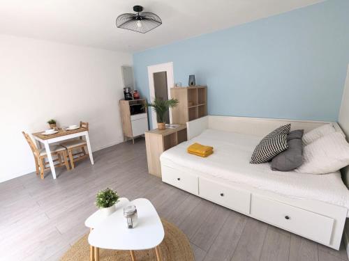 un salon avec un lit et une table dans l'établissement Studio Faubourg-Raines, à Dijon