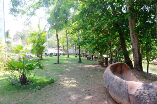 a metal sculpture in a park with trees and benches at Prime Hotel Águas da Serra in Rio Quente