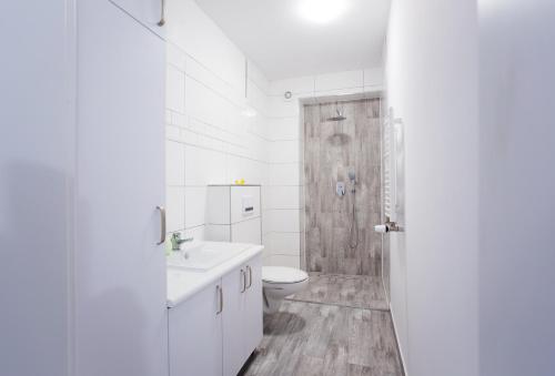 Apartament Morski في شتوتوفو: حمام ابيض مع مرحاض ودش