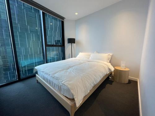 a bedroom with a bed and a large window at C&S Stay- Melbourne CBD in Melbourne