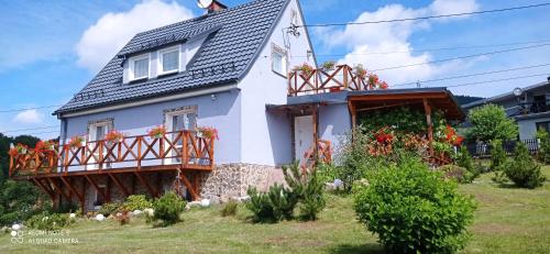 a house with flowers on the balcony of it at Sowi Dom - Jugów in Jugów