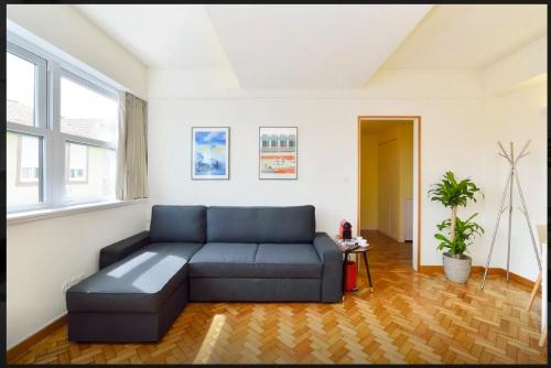 ein Wohnzimmer mit einem blauen Sofa in einem Zimmer in der Unterkunft Studios Baixa Downtown Porto in Porto
