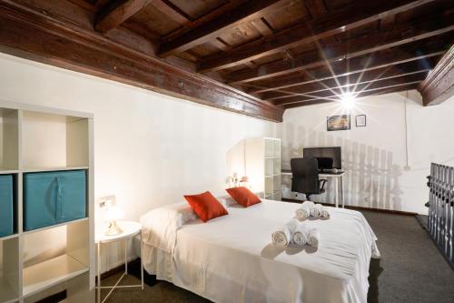 a bedroom with a large white bed and a flat screen tv at De Bardi - Beautiful Home near Ponte Vecchio in Florence