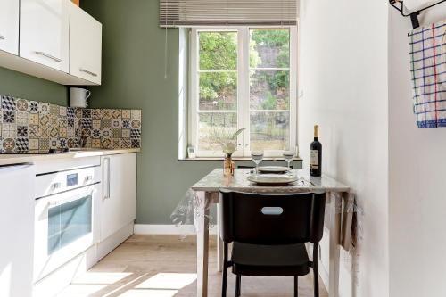 a kitchen with a table with a bottle of wine at L'Étape de la Porte - Appt niché au cœur Mouzon in Mouzon