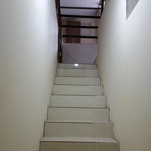 a staircase leading up to a room with white walls at Linda casa com piscina in Saquarema