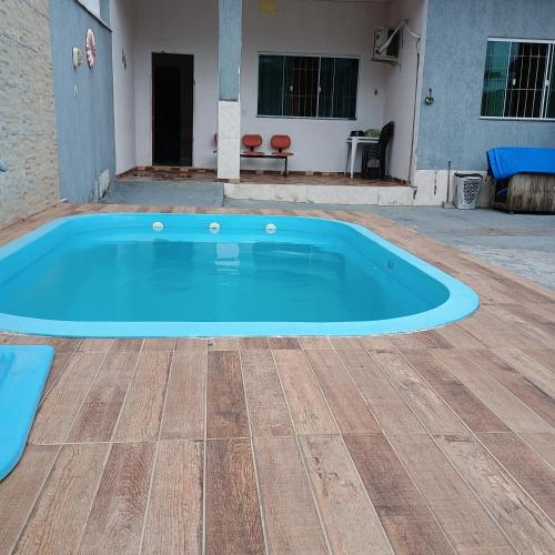 a large blue swimming pool in a yard at Linda casa com piscina in Saquarema