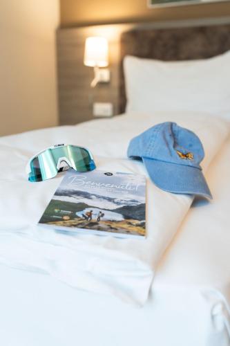 a book on a bed with a hat on it at Hotel Unione in Bellinzona