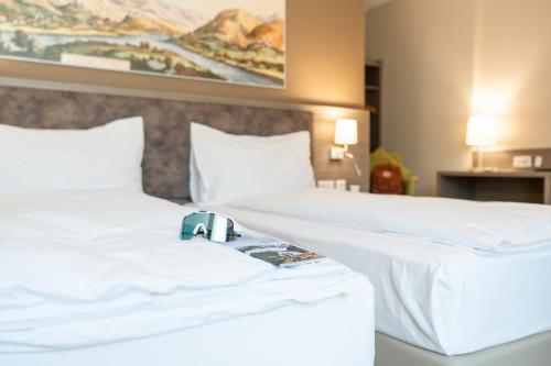 two beds in a hotel room with a camera on them at Hotel Unione in Bellinzona