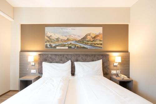 a hotel room with a bed with two white pillows at Hotel Unione in Bellinzona