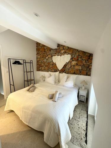 une chambre avec un grand lit avec un mur en pierre dans l'établissement Charming appartement 3BR - 3BA - 3WC, à Cannes