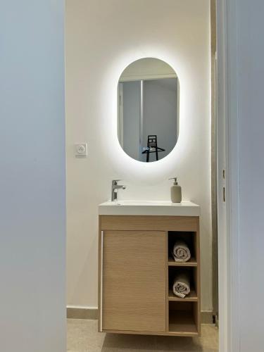 une salle de bain avec un lavabo et un miroir dans l'établissement Charming appartement 3BR - 3BA - 3WC, à Cannes