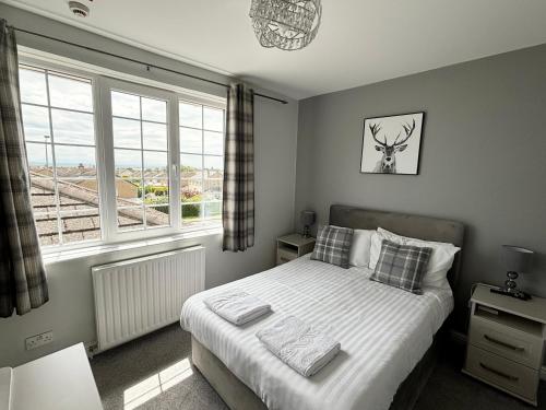 a bedroom with a bed and a large window at Solway Lodge Hotel in Gretna Green