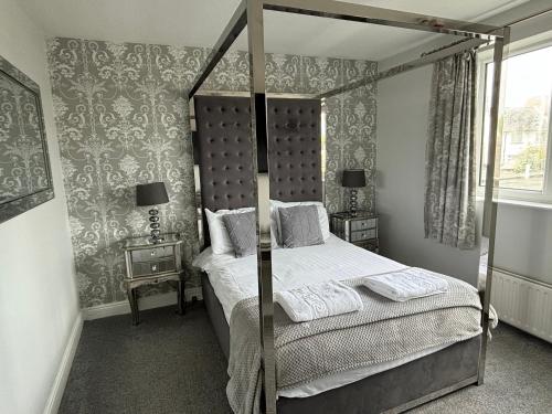 a bedroom with a four poster bed and a window at Solway Lodge Hotel in Gretna Green