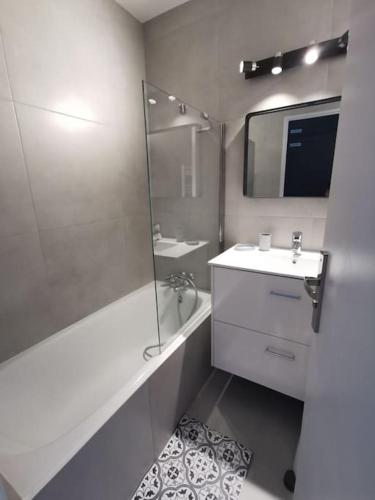 une salle de bain blanche avec un lavabo et un miroir dans l'établissement Superbe appartement rénové, à Allos