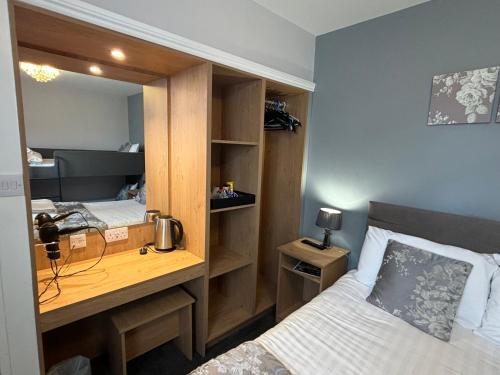a room with two beds and a desk with a mirror at Solway Lodge Hotel in Gretna Green