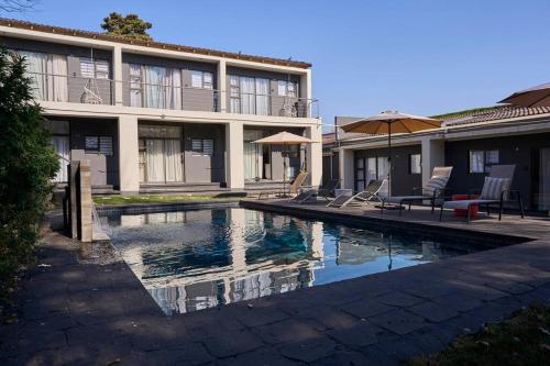 a swimming pool in front of a building at Cosy apt 5min to Sandton City 14 in Johannesburg