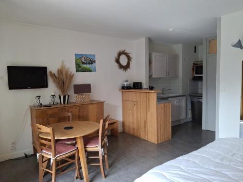 une petite cuisine et salle à manger avec une table et des chaises dans l'établissement Studio accueillant, centre station, balcon, parking, WiFi - FR-1-512-117, à Brides-les-Bains