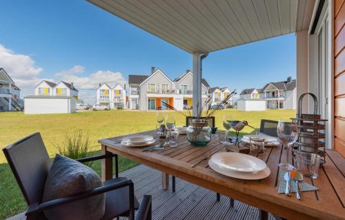 a wooden table on a deck with a view of a yard at Norden in Olpenitzdorf