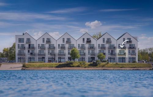 ein großes weißes Gebäude neben einem Wasserkörper in der Unterkunft Meerleben in Olpenitz