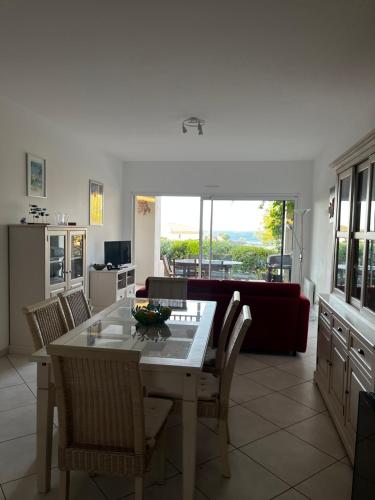 une cuisine et un salon avec une table et des chaises dans l'établissement Appartement avec jardin vue mer, à Lumio