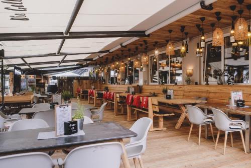 a restaurant with wooden tables and white chairs at Der Gollinger in Saalbach Hinterglemm