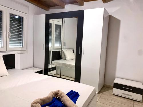 una camera da letto con un letto bianco e uno specchio di Glykeraki's House a Nea Kalikratia