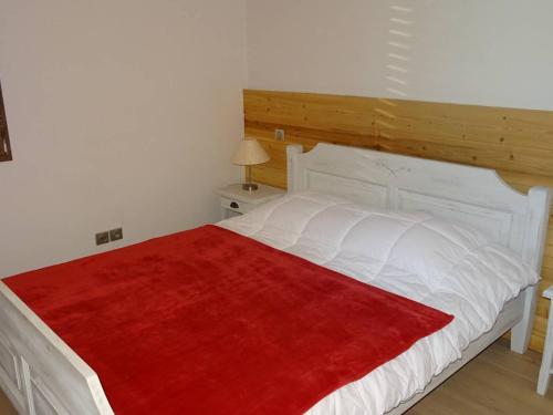 - une chambre avec un grand lit blanc et une couverture rouge dans l'établissement Appartement lumineux aux Gets, 3 pièces, garage, confort, 5 pers, WiFi, proche pistes - FR-1-802-32, aux Gets