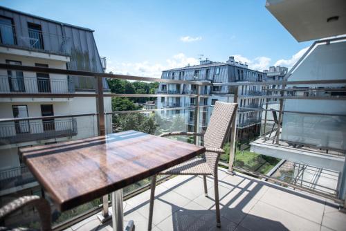 a balcony with a wooden table and chairs on a balcony at Apartamenty na Wyspie - Villa Pegaz - Parking in Świnoujście