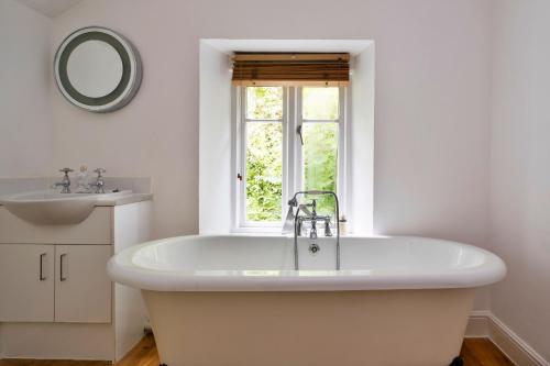 Un baño blanco con bañera y lavabo. en Finest Retreats - Riversdale Lodge, en Symonds Yat