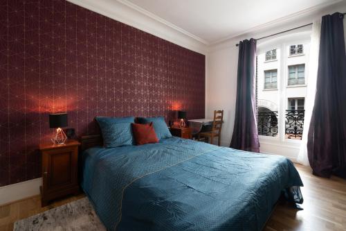 - une chambre avec un lit bleu et un mur rouge dans l'établissement Art de Vivre - Très bel appartement à Paris, à Paris