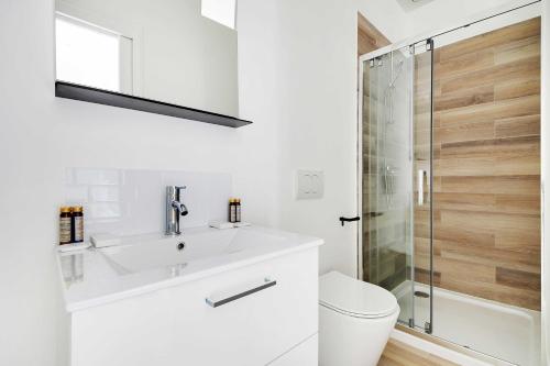 une salle de bain blanche avec un lavabo et une douche dans l'établissement Charming apt with patio - 2BD4P - Monceau Park, à Paris