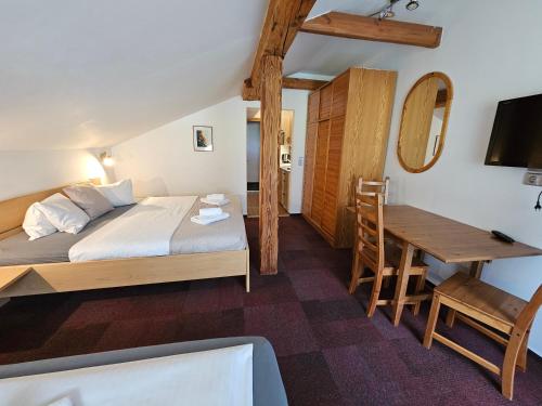 a bedroom with a bed and a table and a desk at Ski&Bike Nassfeld Apartments in Hermagor