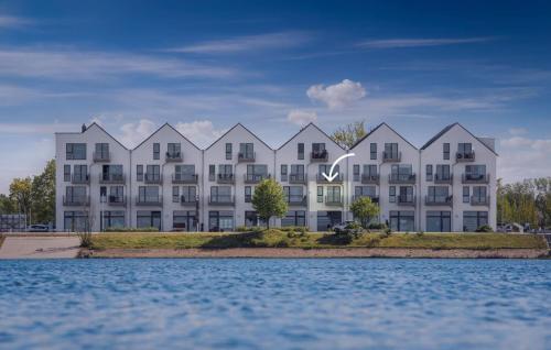 een weergave van een groot wit appartementengebouw naast het water bij Take Five in Olpenitz