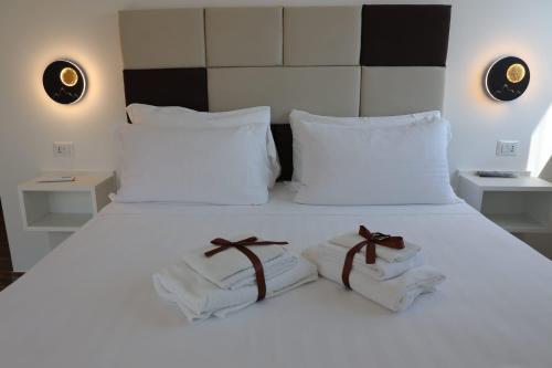 a bedroom with a white bed with towels on it at Domus Mamurra in Formia