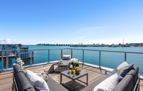 a balcony with couches and a table with a view of the water at Navia in Olpenitz
