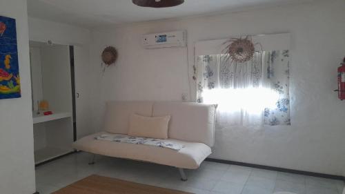 a living room with a white couch and a window at Maison Amantine in Mahe