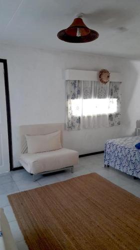a living room with a chair and a bed at Maison Amantine in Mahe